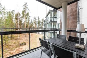 balcón con mesa, sillas y ventana en Finlandia Hotel Imatran Kylpylä Spa, en Imatra