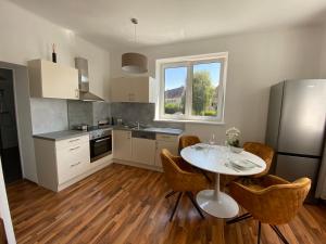 eine Küche mit einem weißen Tisch und Stühlen sowie einem Fenster in der Unterkunft Design-Appartement Steyr in Steyr