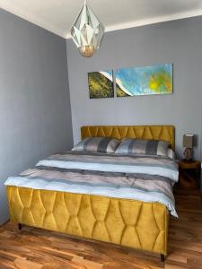 a bed in a bedroom with a yellow headboard at Design-Appartement Steyr in Steyr