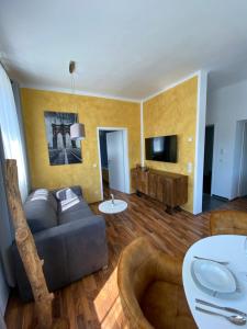 a living room with a couch and a tv at Design-Appartement Steyr in Steyr