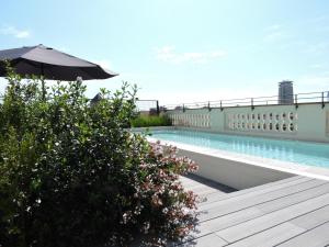 uma piscina com um guarda-sol num edifício em Hotel Raval House em Barcelona