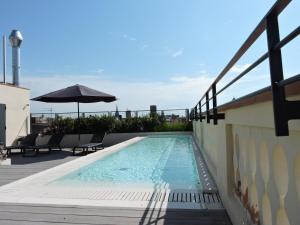 a swimming pool on top of a building with an umbrella at Hotel Raval House in Barcelona