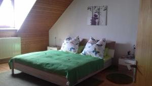 a bedroom with a bed with green sheets and pillows at Ferienwohnung Bergblick in Trittenheim