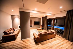 ein großes Wohnzimmer mit Sofas und einem TV in der Unterkunft Villa Estate in Novalja