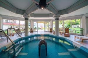 an indoor swimming pool with a large ceiling at Hotel Alexanderhof in Millstatt