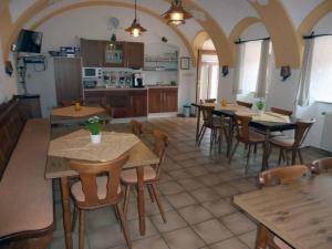 a dining room with tables and chairs and a kitchen at Ferienwohnung Pension Hauer Hof in Wegscheid