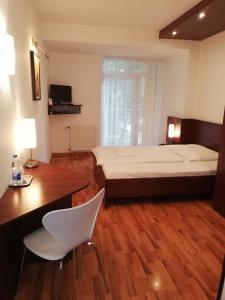 a bedroom with a large bed and a desk and chair at Hotel Arli in Senica