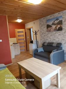 een woonkamer met een bank en een tafel bij Pokoje i apartamenty u Bartka in Szczawnica