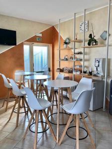 een groep tafels en stoelen in een keuken bij La Siesta Bed&Residence in Cardano al Campo