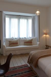 Boetiekhotel Hemelhuys في هاسيلت: غرفة معيشة مع أريكة أمام نافذة