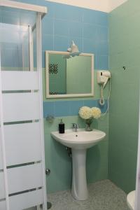 een badkamer met een wastafel en een spiegel bij VesuView Guest House near the Ruins in Pompei