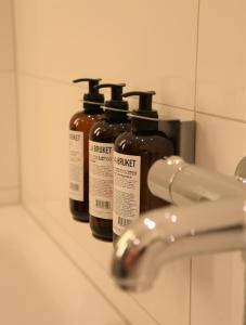 a group of four bottles of honey sitting on a bathroom sink at FREIgeist Northeim in Northeim