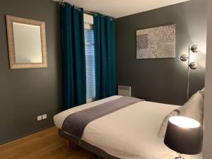 um quarto com uma cama e cortinas azuis em Appartement Disneyland au centre du Val d'Europe em Chessy