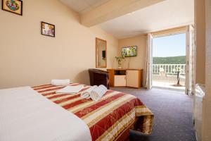 ein Hotelzimmer mit einem Bett und einem Balkon in der Unterkunft Hotel Luna in Neum