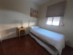ヘレス・デ・ラ・フロンテーラにあるApartamento Zona Norteのベッドルーム(白いベッド1台、窓付)