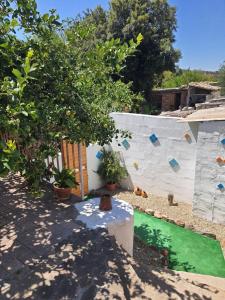 un patio trasero con una pared de roca y una piscina en Dwelling Zara, en Solèminis