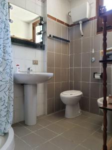 a bathroom with a sink and a toilet and a mirror at Dwelling Zara in Solèminis