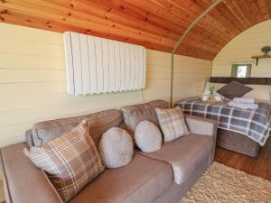 a living room with a couch and a bed at Valley View in Rhayader