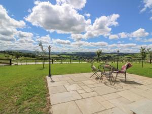 a patio with two chairs and a table on a field at Valley View in Rhayader