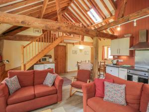 a living room with two couches and a kitchen at The Old Cart Shed in Fordingbridge