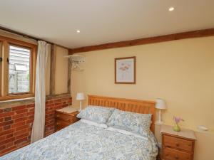 1 dormitorio con cama y ventana en The Old Cart Shed en Fordingbridge