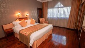 a hotel room with a large bed and a window at LAOTEL VIENTIANE in Vientiane