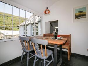 ein Esszimmer mit einem Holztisch und Stühlen in der Unterkunft Harbour Cottage in Boscastle