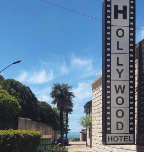 un panneau d'hôtel devant un bâtiment dans l'établissement Hotel Hollywood, à Lazarevskoïe