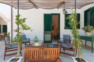 patio con sedie, tavolo e persiane verdi di Masseria Il Roseto ai Cappuccini by Wonderful Italy a Martina Franca
