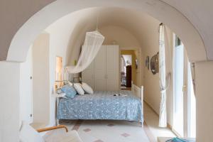 una camera con letto in una stanza con arco di Masseria Il Roseto ai Cappuccini by Wonderful Italy a Martina Franca