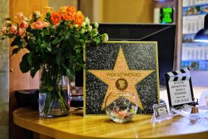 une étoile sur une table avec un vase de fleurs dans l'établissement Hotel Hollywood, à Lazarevskoïe