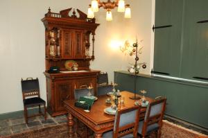 een eetkamer met een houten tafel en stoelen bij Bed en kerk monumentale 2 slaapkamer woning in Hoorn