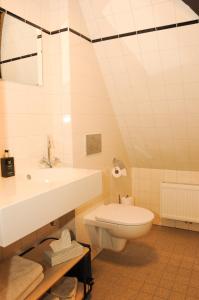 Baño blanco con lavabo y aseo en Bed en kerk monumentale 2 slaapkamer woning, en Hoorn