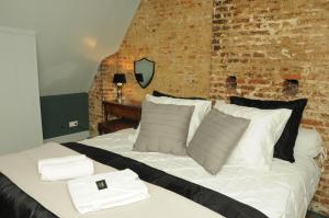 a bedroom with a white bed with a brick wall at Bed en kerk monumentale 2 slaapkamer woning in Hoorn