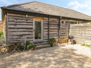 a log cabin with a porch and a door at Pond View in Fordingbridge