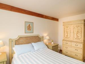 a bedroom with a large bed and a dresser at Pond View in Fordingbridge