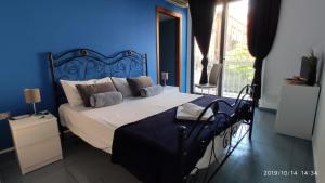 - une chambre dotée d'un lit avec un mur bleu dans l'établissement Luxury Catania, à Catane