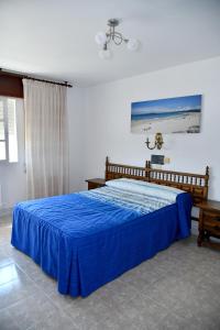 a bedroom with a bed with a blue bedspread at Hotel Maruxa in A Lanzada