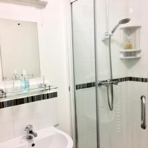 a bathroom with a shower and a sink at Rosalie Guest House in Penzance