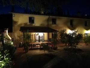 ein Haus mit einem Tisch und einer Terrasse in der Nacht in der Unterkunft vacanza nel verde in Prato