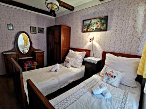 a bedroom with two twin beds and a mirror at Apartment Slavonska Kuća in Pleternica