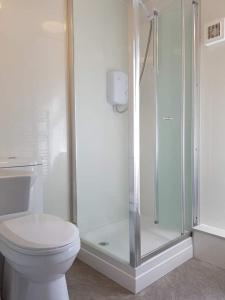 a bathroom with a toilet and a glass shower at Atticus Central Guest House in Aberdeen