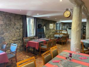 a restaurant with tables and chairs and a clock on the wall at Le Mas Saint Donat in Sainte-Maxime