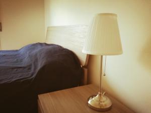 eine Lampe auf einem Tisch neben einem Bett in der Unterkunft Casa Maresole in Diano Marina