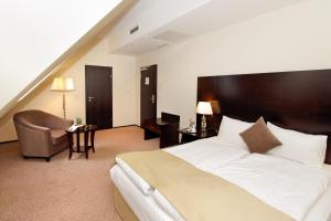 a hotel room with a large bed and a chair at Grand Palace Hotel Hannover in Hannover