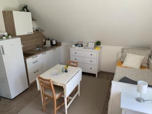 eine kleine Küche mit einem weißen Tisch und einem Sofa in der Unterkunft Steira-Studios in Ehrenhausen