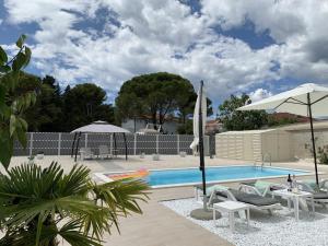 a swimming pool with chairs and umbrellas next to at Romantik Pearl with free EV Ch-Station in Valbandon