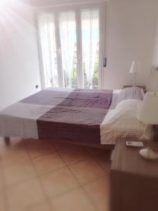 a bedroom with a large bed with a large window at Casa Maresole in Diano Marina
