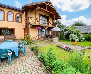 a house with a table and chairs in the yard at Rodynnyi Zatyshok in Verkhovyna