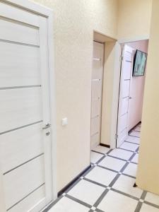 アドレルにあるЦентр Адлера - Квартираの白いドアとタイル張りの床の廊下